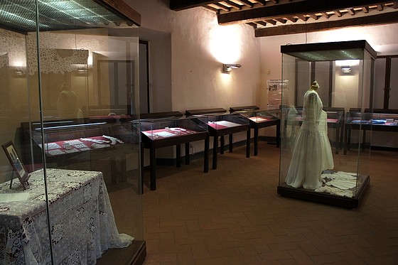 La robe de mariage trône au centre de la salle d'exposition des ouvrages en dentelle réalisés à l'Isola Maggiore.