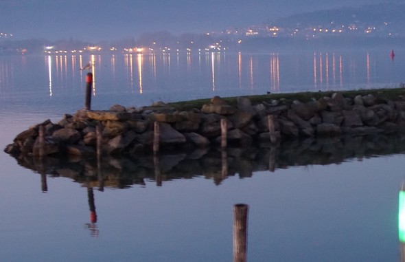 Digue de la deuxième darse de l'Isola Maggiore.Les feux rouge (babord) et vert (tribord) de son entrée.Au fond, la rive nord du lac Trasimène avec les lumières de Tuoro-sul-Trasimeno.