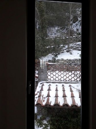 Coup d'oeil depuis notre cage d'escalier.Encore de la neige sur les tuiles, le sentier et le versant de la colline derrière la maison.